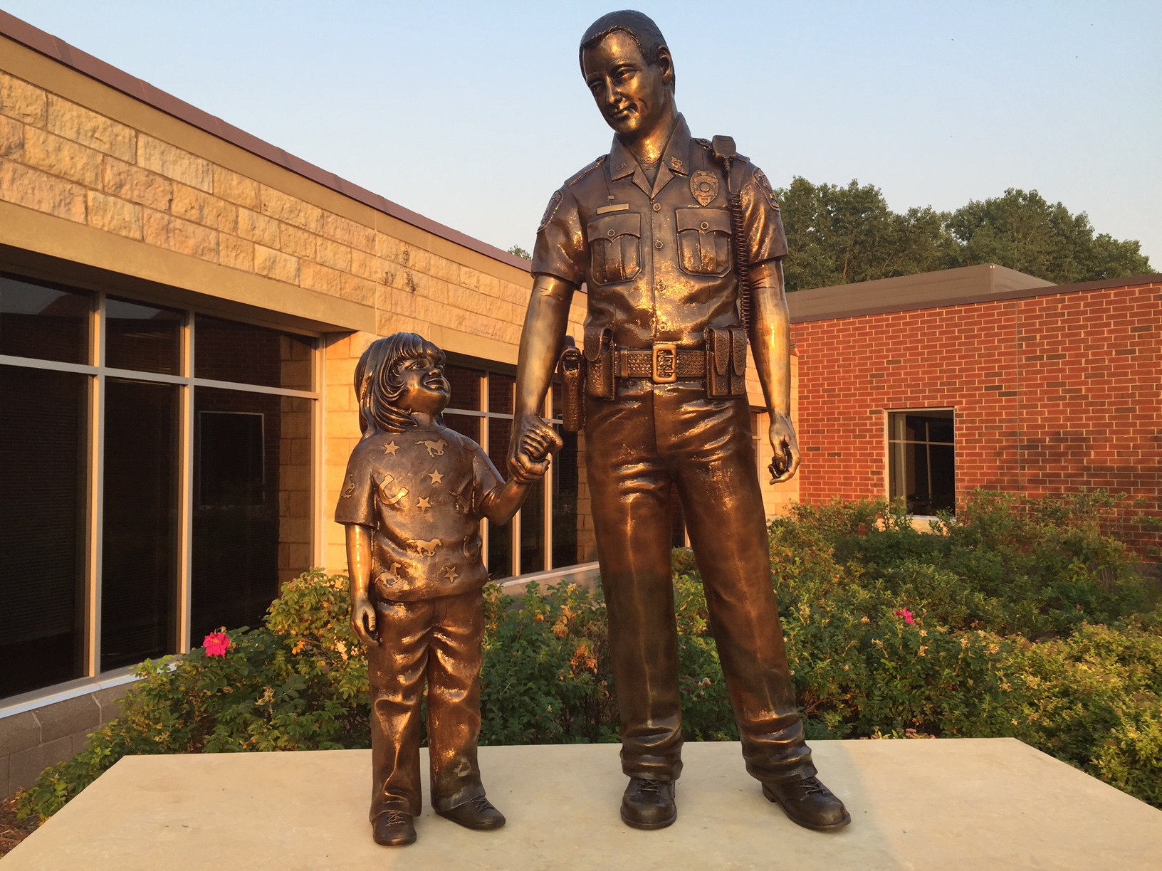 Bronze police officer in uniform with child statues