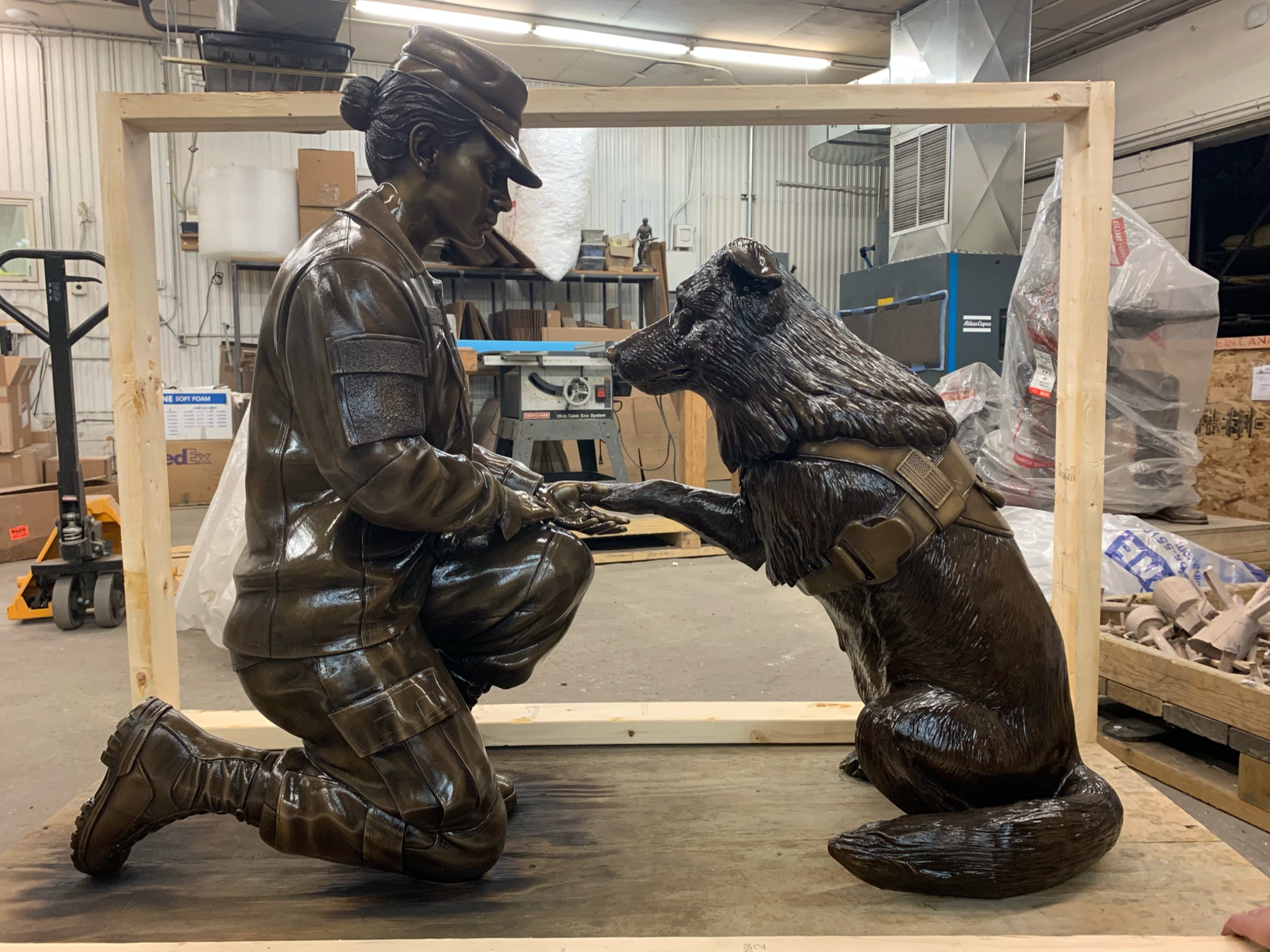 Bronze military memorial female soldier statue shaking paw of canine