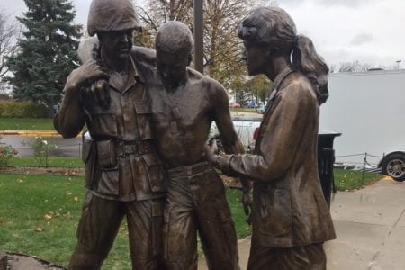 Bronze military memorial corpsman assisting a wounded soldier statue with VA nurse statue