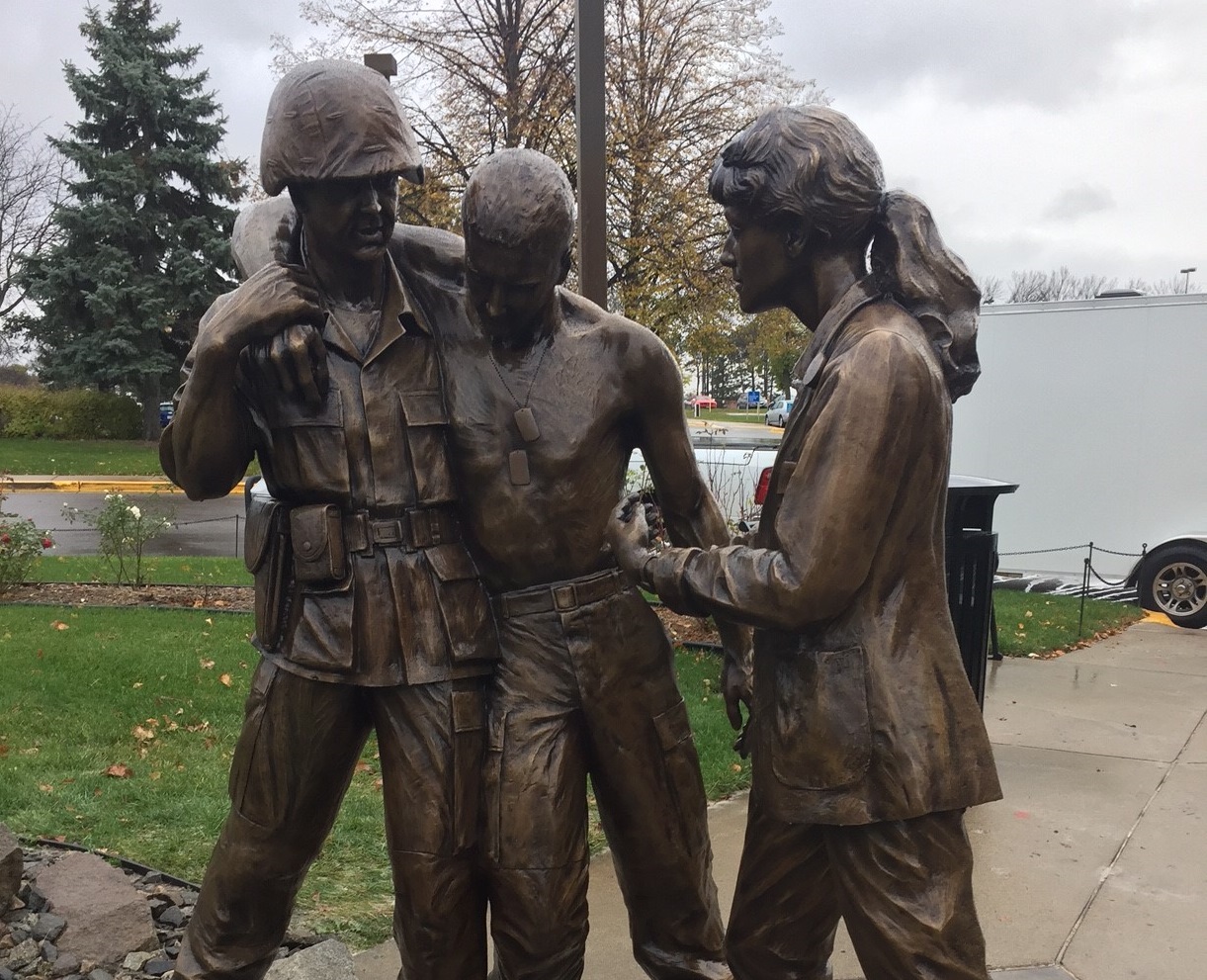 Bronze military memorial corpsman assisting a wounded soldier statue with VA nurse statue