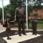 Bronze police protector officer statue in uniform with children