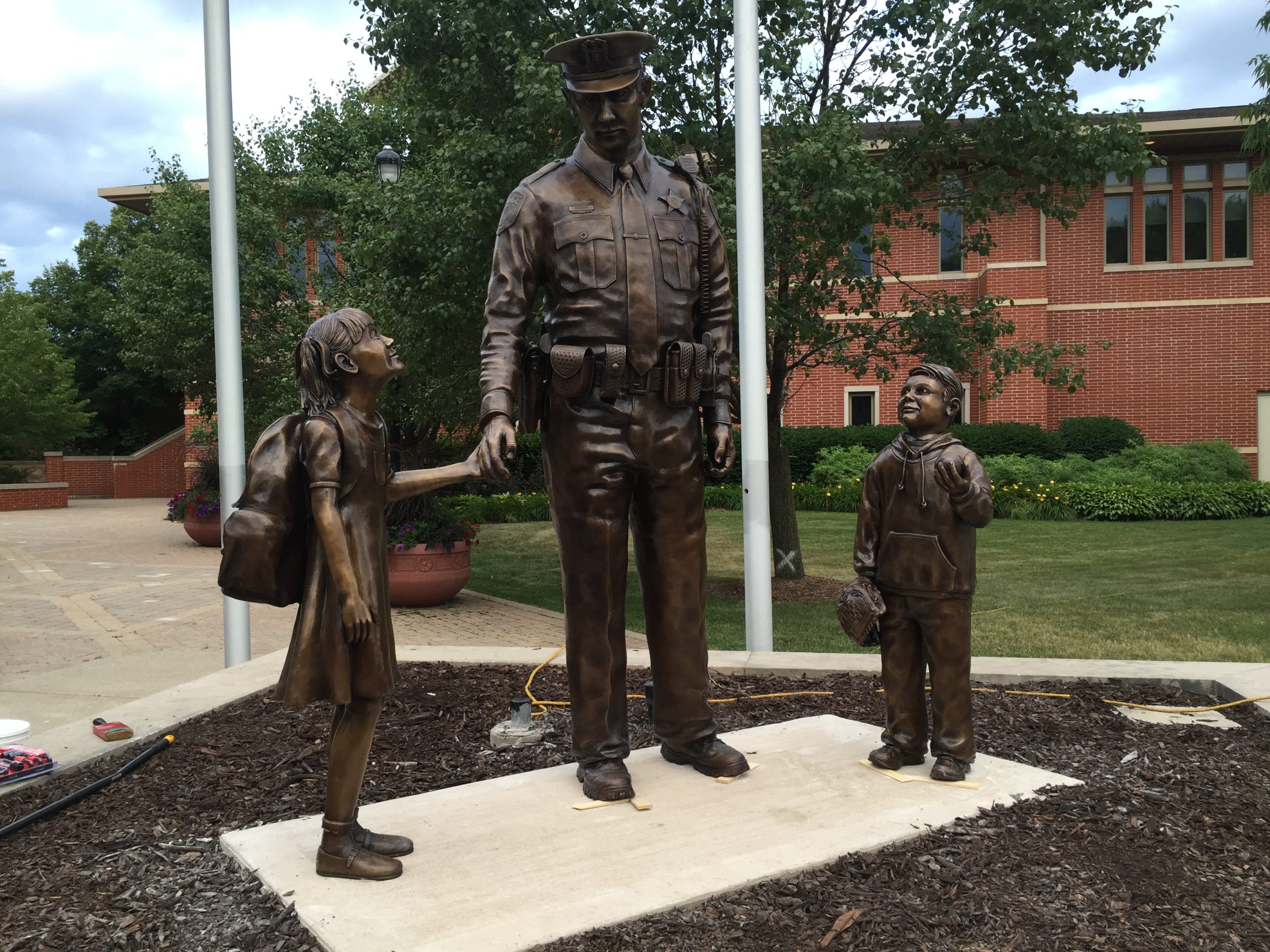 Bronze police protector officer statue in uniform with children