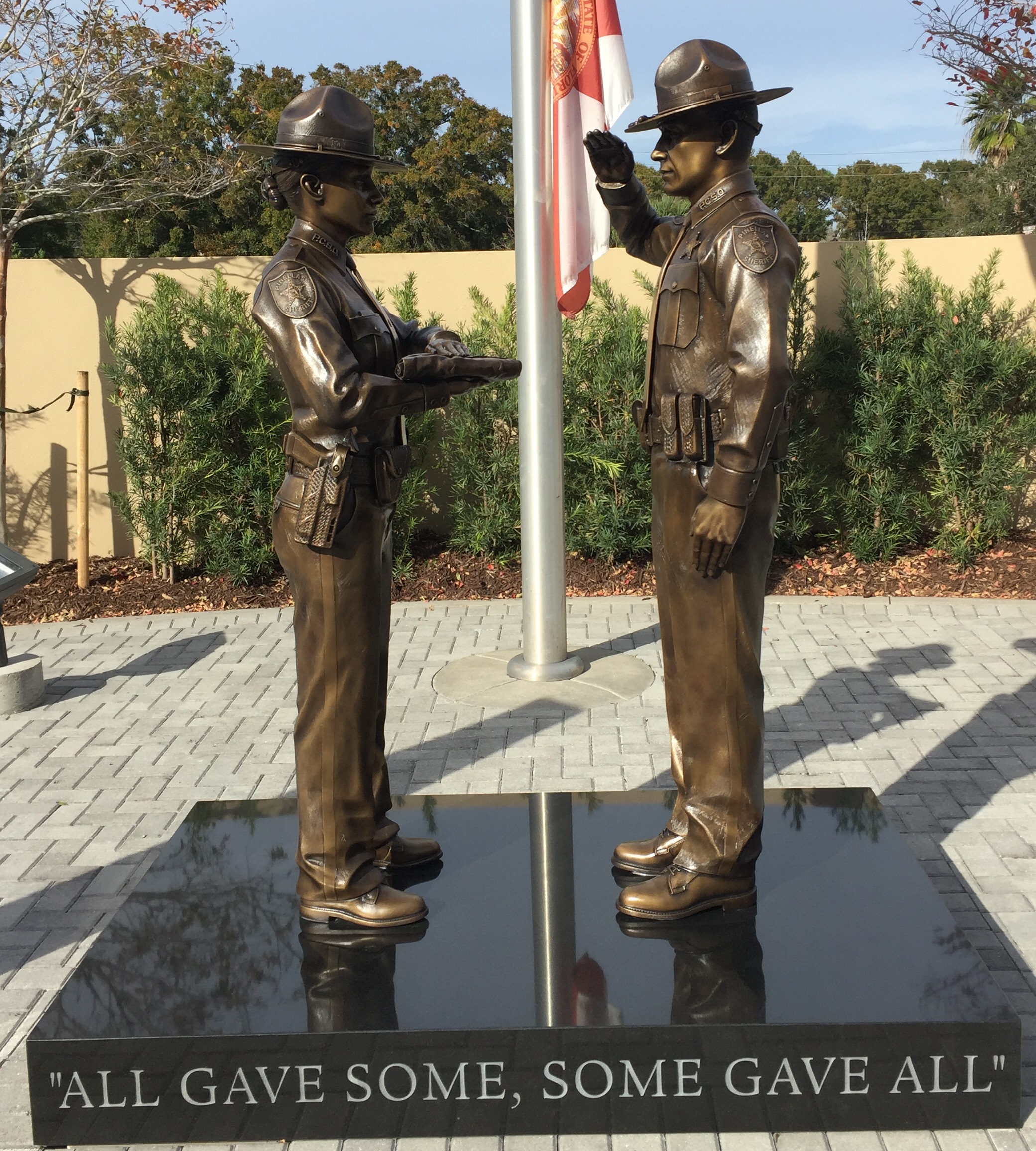 Bronze law enforcement honor guard statues: deputy presenting the flag and deputy saluting