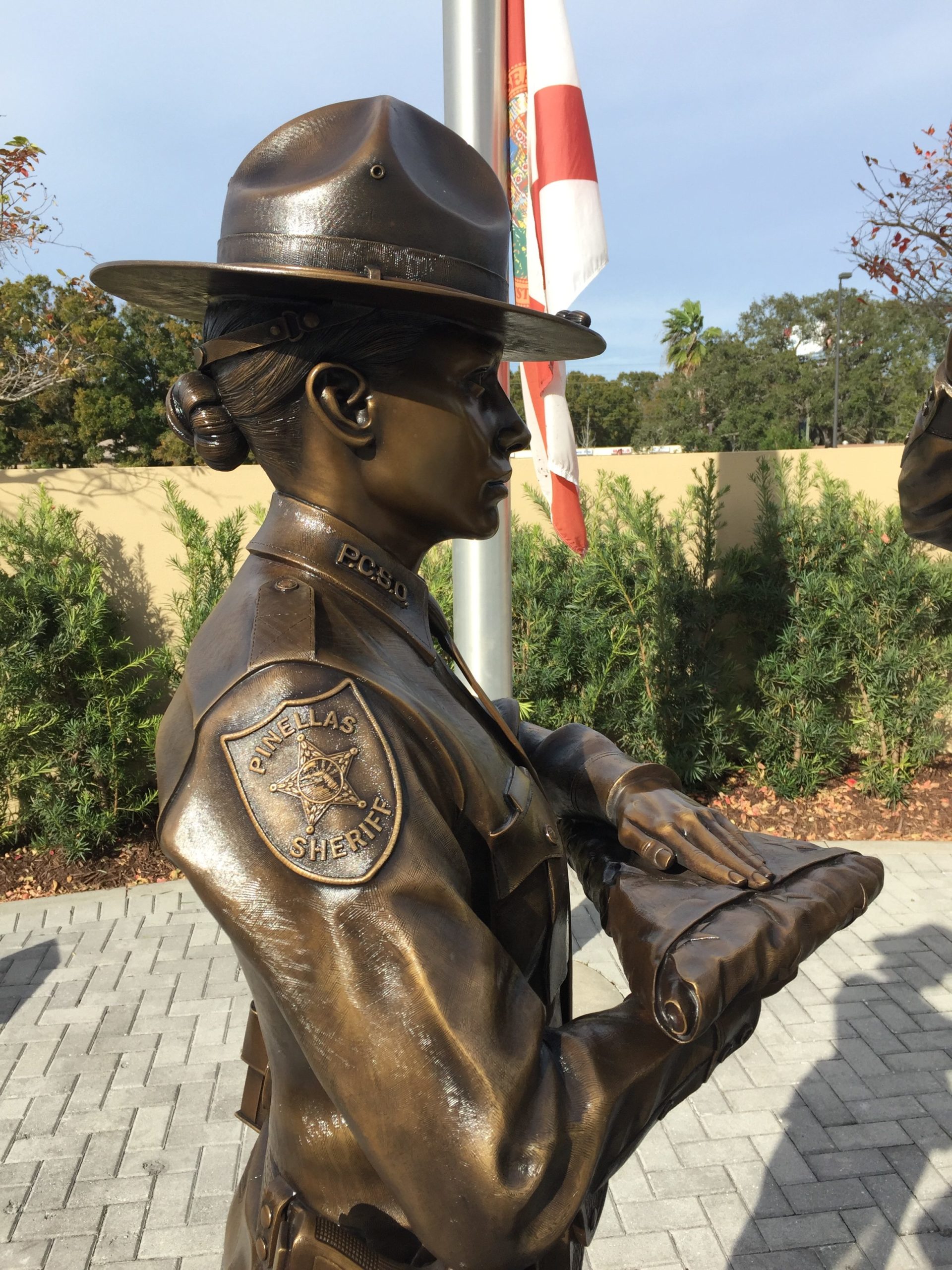 Honor Guard Bronze officer holding flag paying tribute