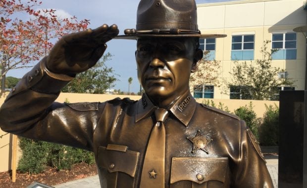 Close up of Bronze officer saluting in honor of fallen officer.