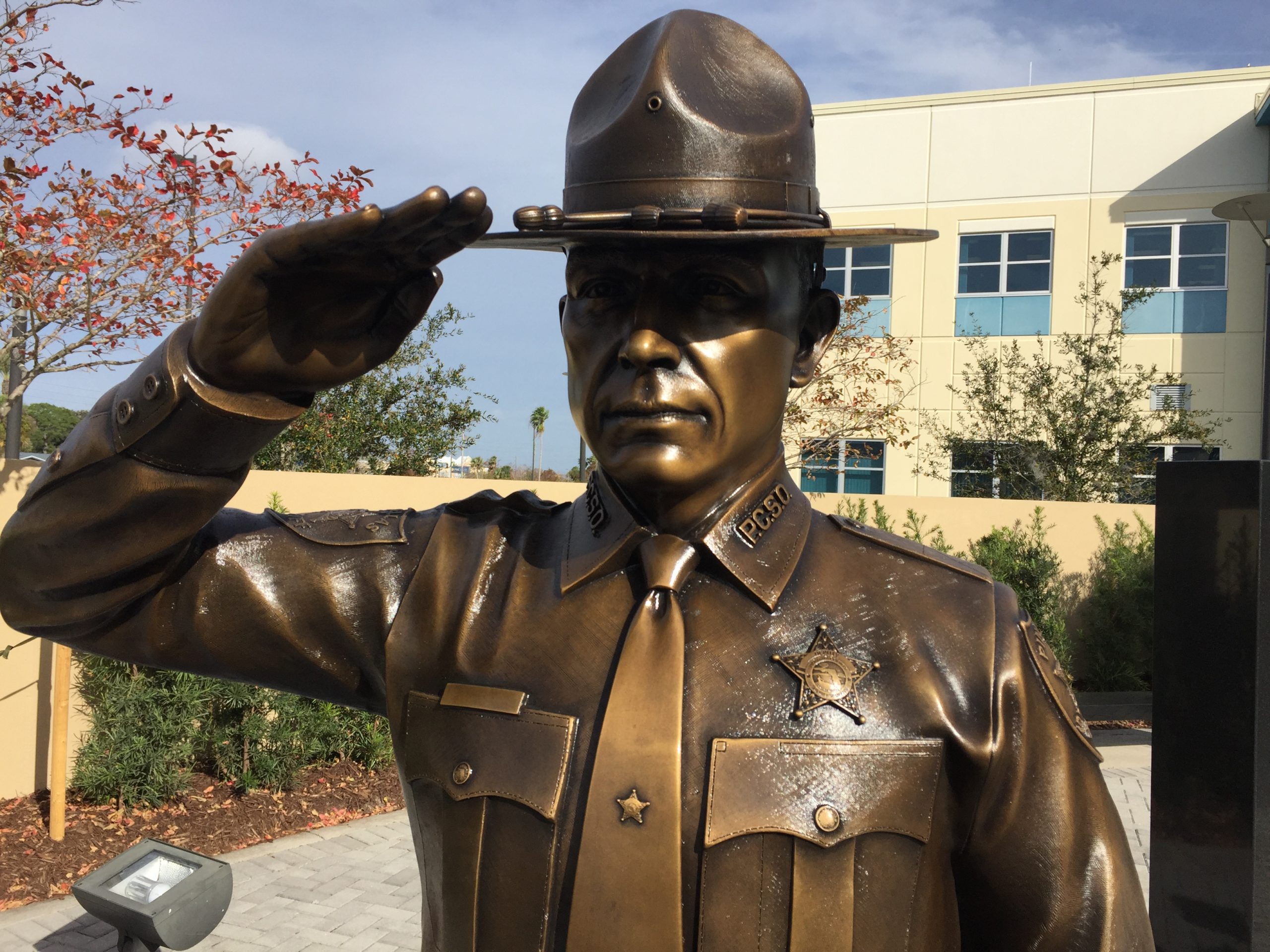 Close up of Bronze officer saluting in honor of fallen officer.