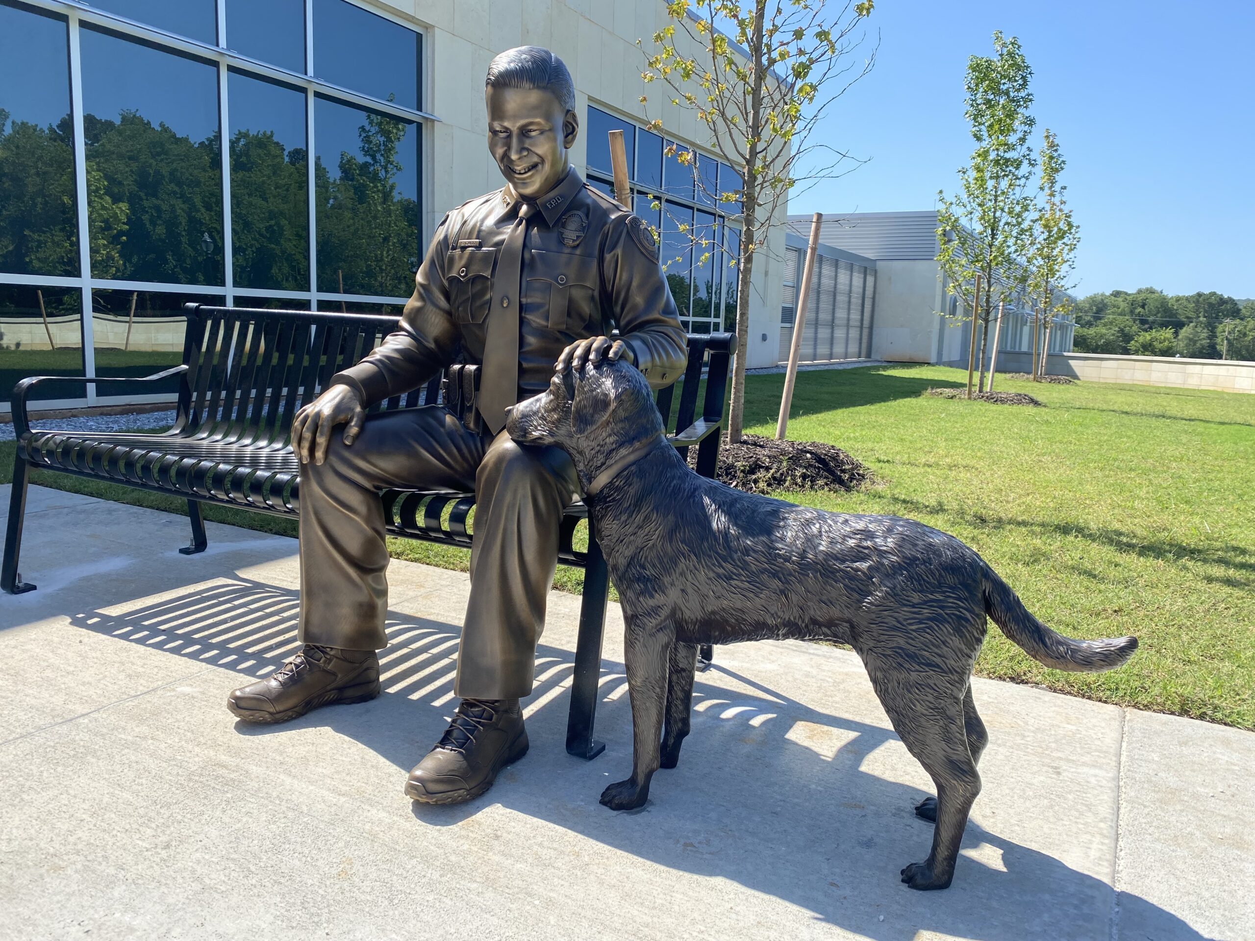Bronze statue of Stephen Carr petting a dog