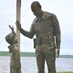 Bronze police officer in uniform with child statues