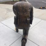 Back of life size bronze sculpture police officer kneeling