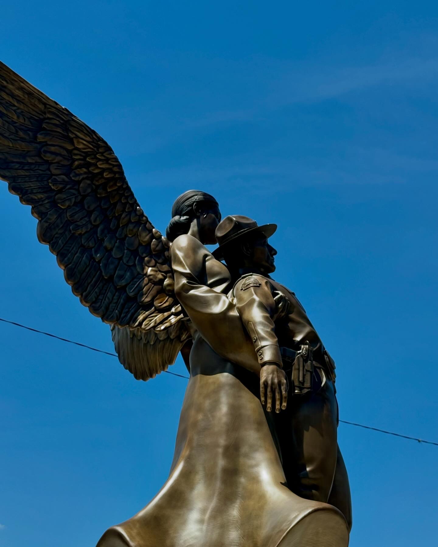 bronze angel holding fallen officer statue