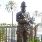 Bronze firefighter in uniform holding child statue