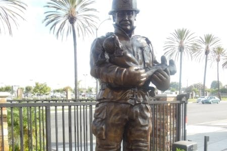 Bronze firefighter sculpture in uniform holding child statue
