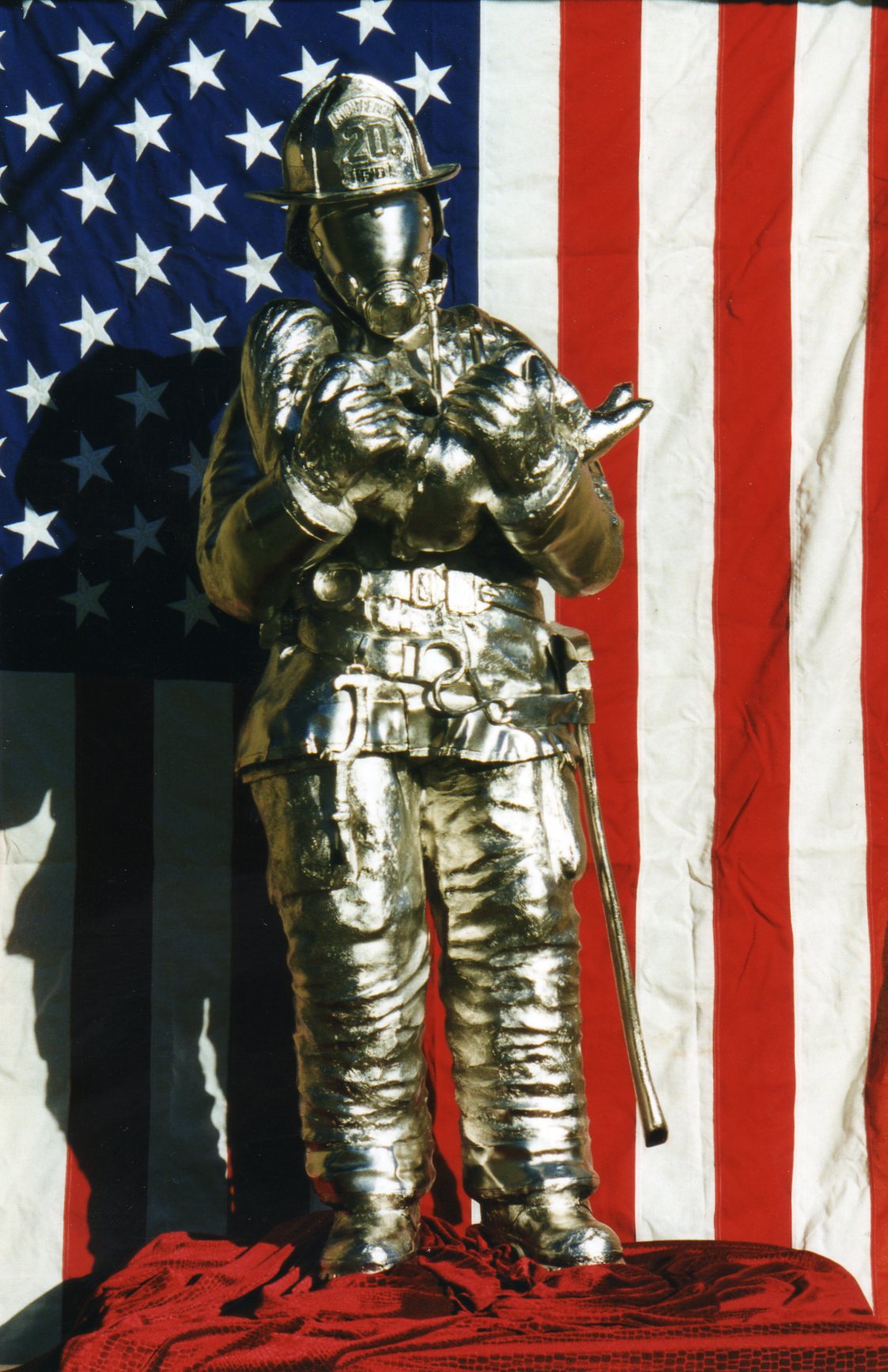 firefighter sculpture in front of flag