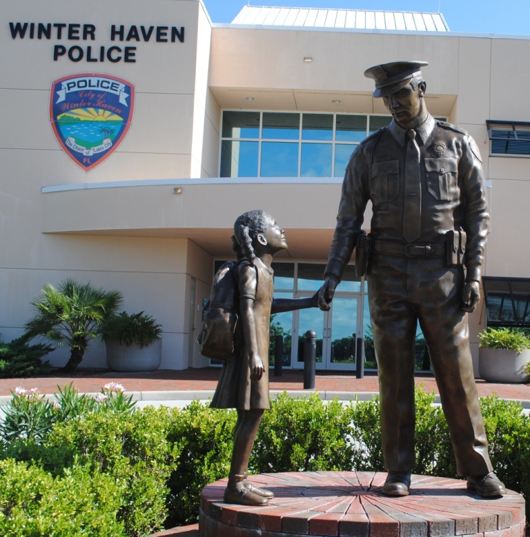 officer and child in front of building